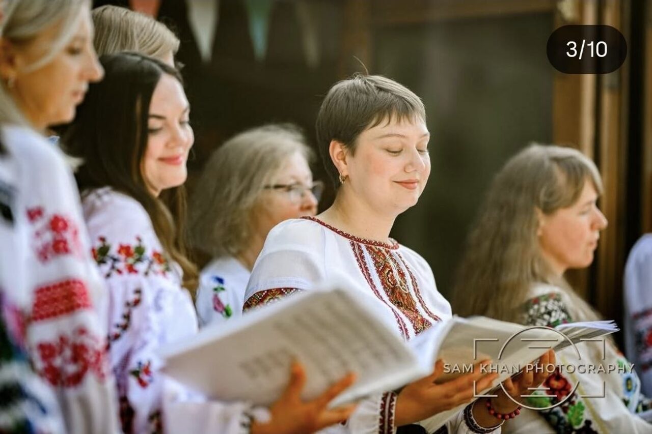 Close-up of Ukrainian Voices choir members singing from songbooks.