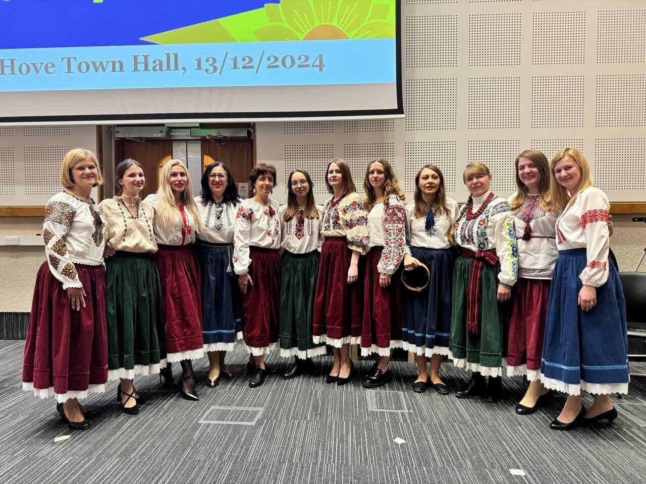 Ukrainian Voices choir members standing together in traditional dress after a concert at Hove Town Hall.